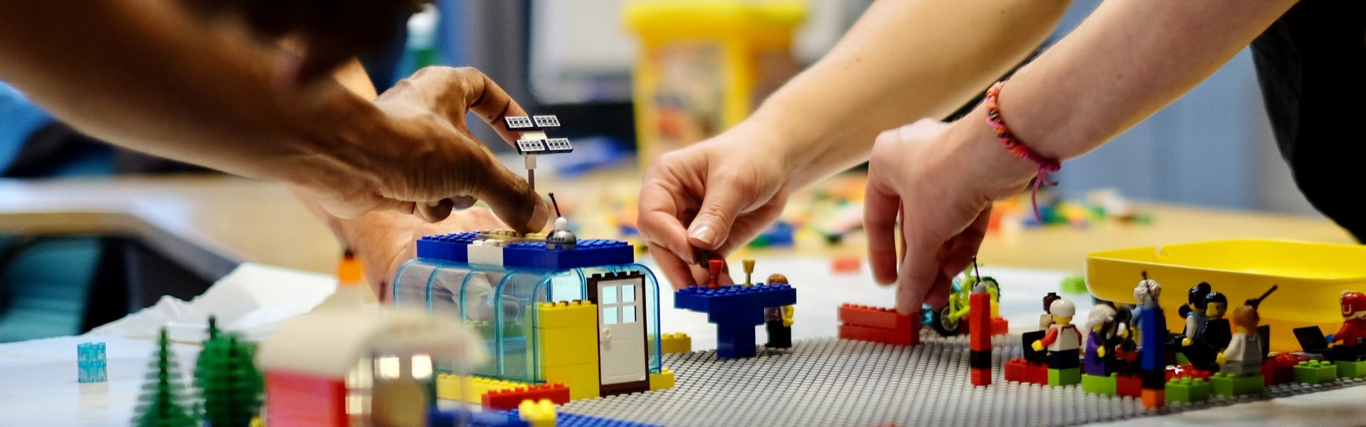 Participants of a LEGO® SERIOUS PLAY® workshop building connections and playing scenarios with models